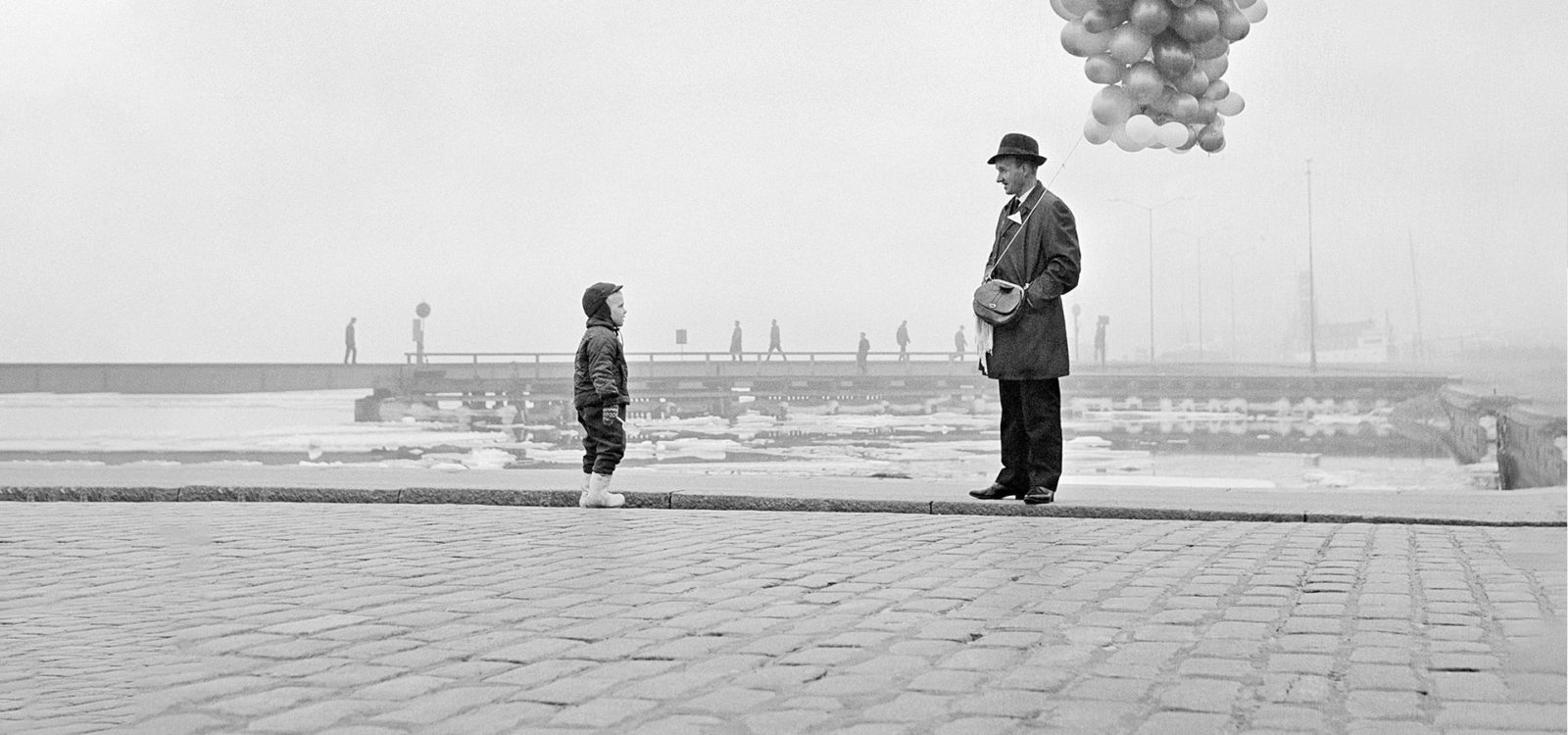 Mies, ilmapallot ja lapsi Kauppatorilla 1964
