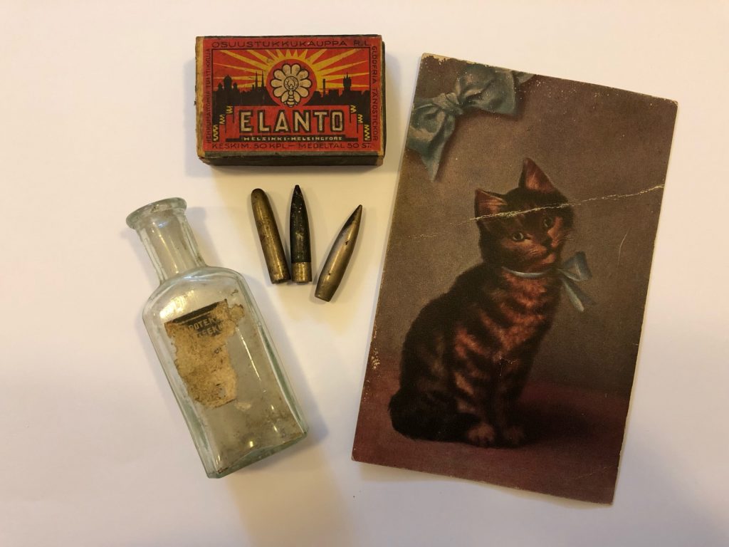 Vanhoja tavaroita: postikortti, tulitikut, lasipullo